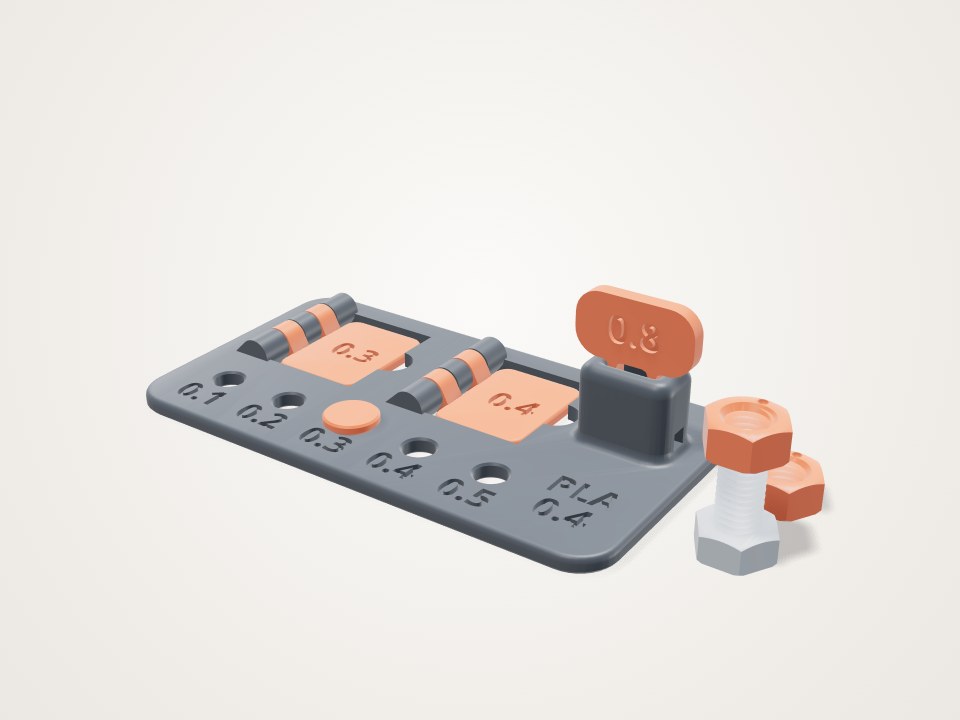 Grey test plate with numbered holes, two orange hinge flaps, a snap key, and an M8 bolt with two nuts