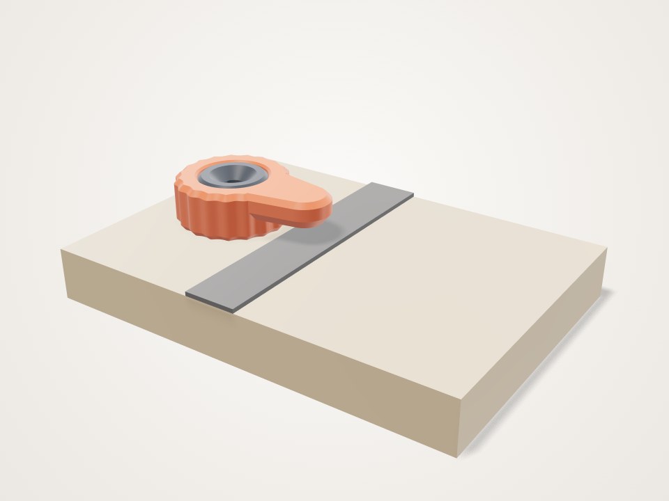 Small orange turn button with a ridged round knob and a flat arm, resting on a board beside a grey strip