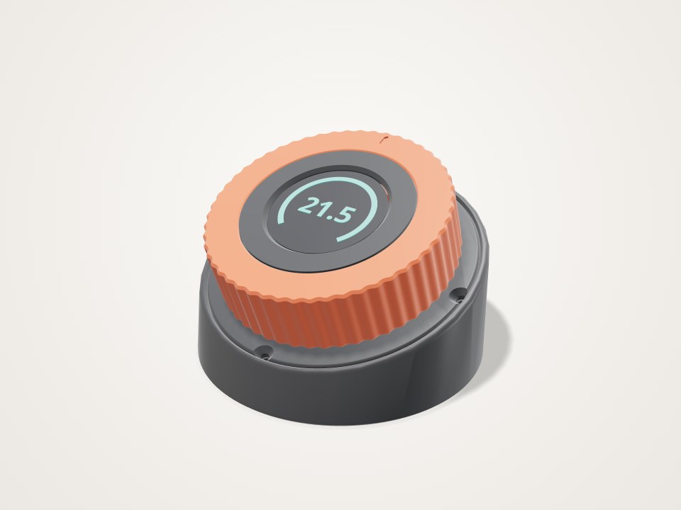 Round desk knob with an orange ridged ring around a small round display, tilted on a dark base